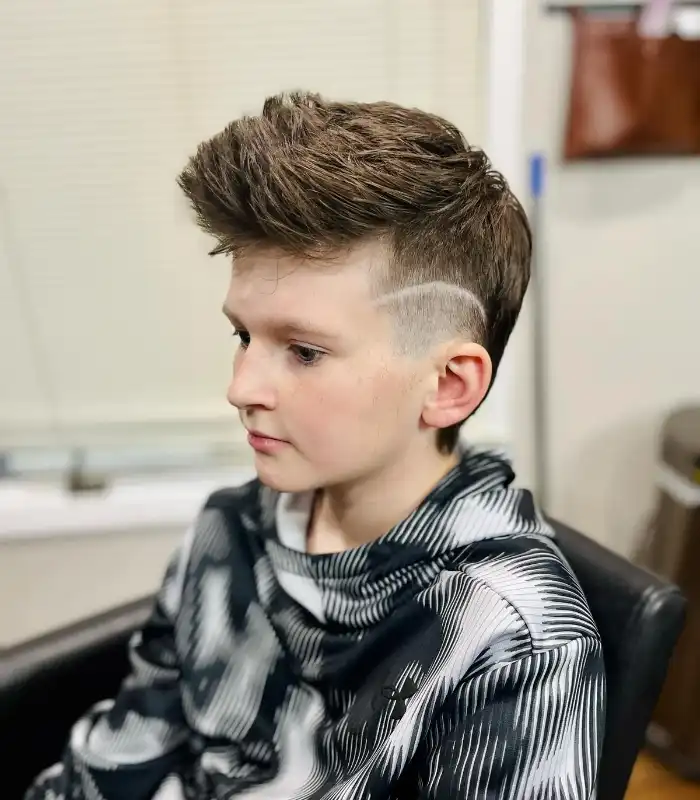 A trendy boys' hairstyle: the tapered mullet, combining a clean undercut with a flowing mullet.