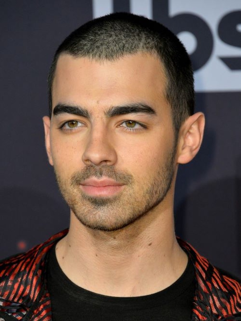 A man with a sharp buzz cut and well-groomed beard showcases how the two styles complement each other for a clean, masculine look