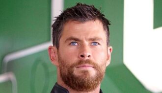 Chris Hemsworth short spiky dark hair with textured layered cut, styled slightly tousled in a well-groomed manner