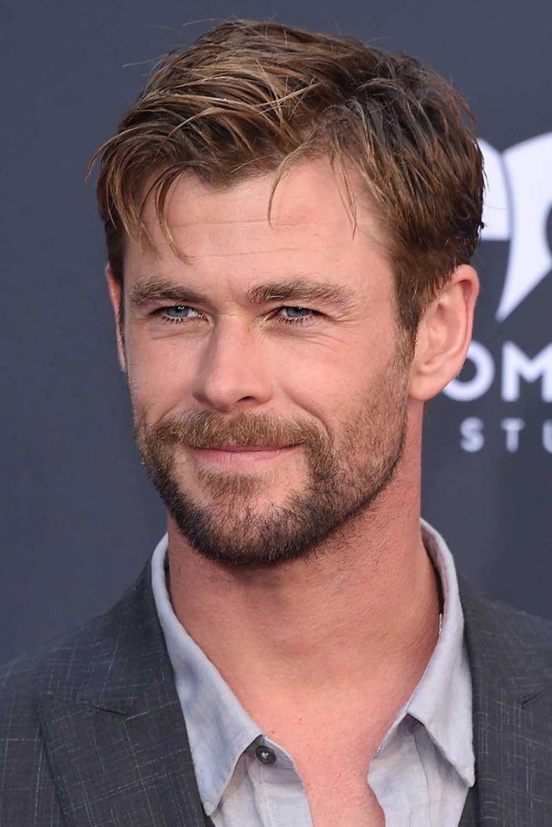 Chris Hemsworth with short textured brown hair styled in a modern tousled cut with subtle layers and a slightly messy voluminous top