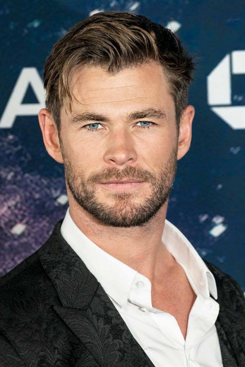 Chris Hemsworth with short textured brown hair with subtle blonde highlights, styled in a neat slightly tousled cut with volume on top