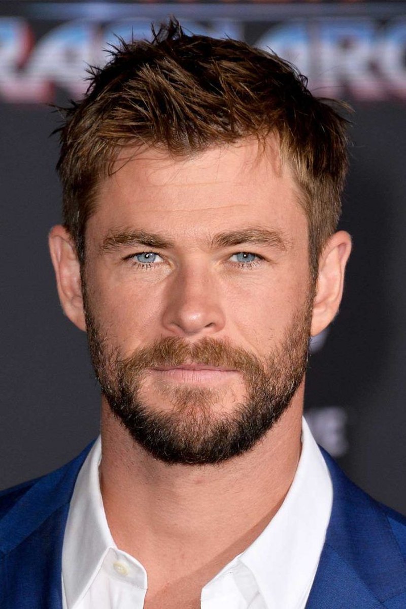 Chris Hemsworth with short textured brown hairstyle featuring spiky tousled layers and a clean modern cut