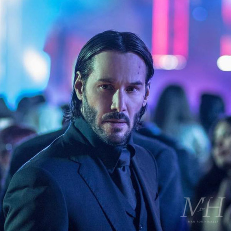 Keanu Reeves' sleek medium-length side-swept center-parted hairstyle as John Wick