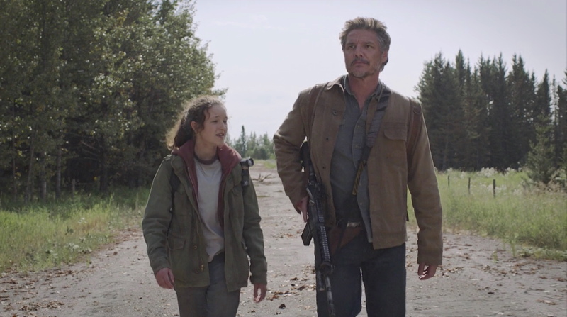Pedro Pascal as Joel Miller with short textured salt and pepper hair styled in a slightly tousled lived-in manner walking a desolate road