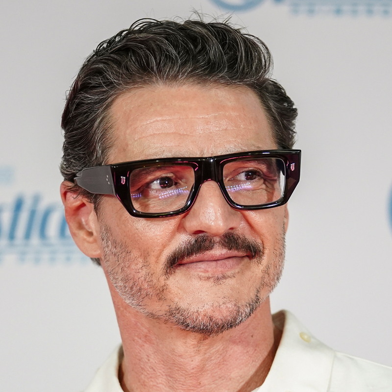 Pedro Pascal wavy swept back quiff hairstyle with medium length hair pushed back off the forehead for a polished red carpet look