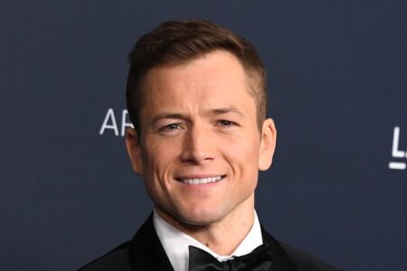 Taron Egerton medium length hairstyle with widow's peak swept back