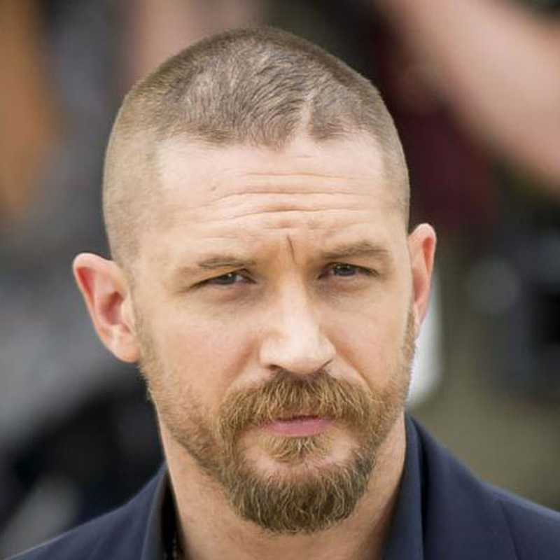 Tom Hardy with a short buzz cut and full beard in Mad Max Fury Road
