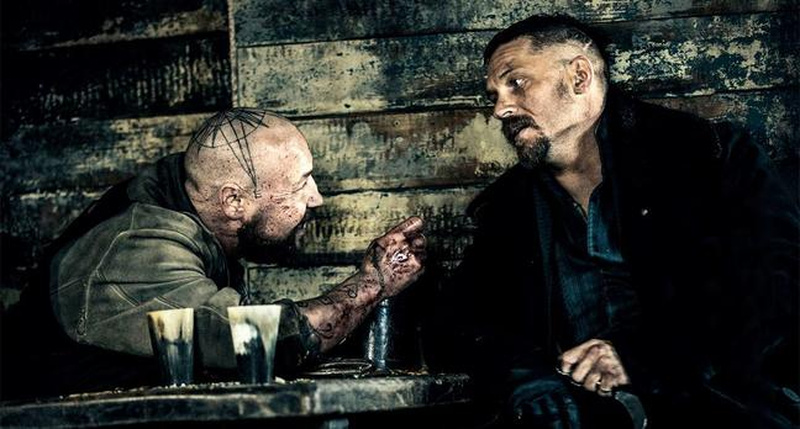 Tom Hardy with short textured top and high skin fade on sides in a rugged style