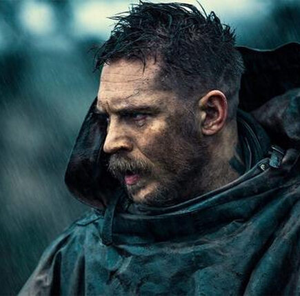 Tom Hardy with spiky textured top and sharp fade paired with a thick beard
