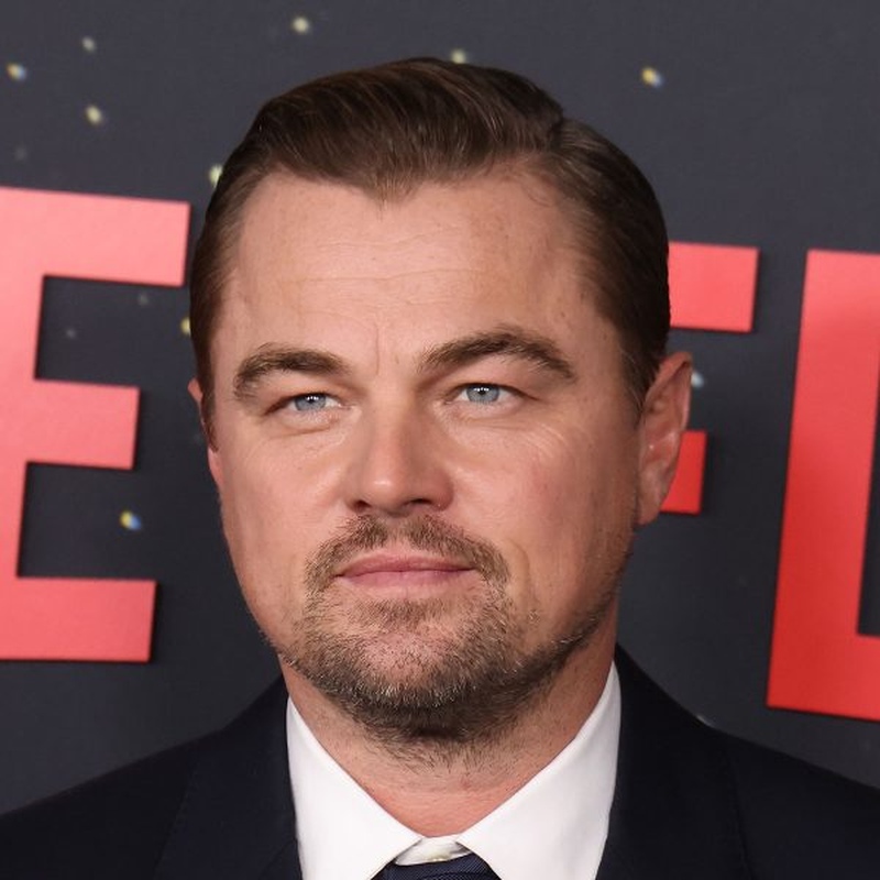 Young Leonardo DiCaprio as Jack Dawson in Titanic with his signature 90s curtain haircut featuring a middle part and soft face-framing fringe